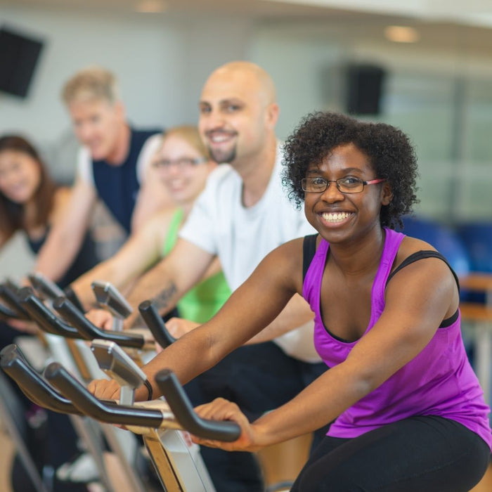 5 people using their one exercise bikes in the gym