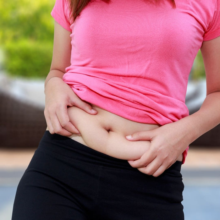 Lady feeling her belly fat before training