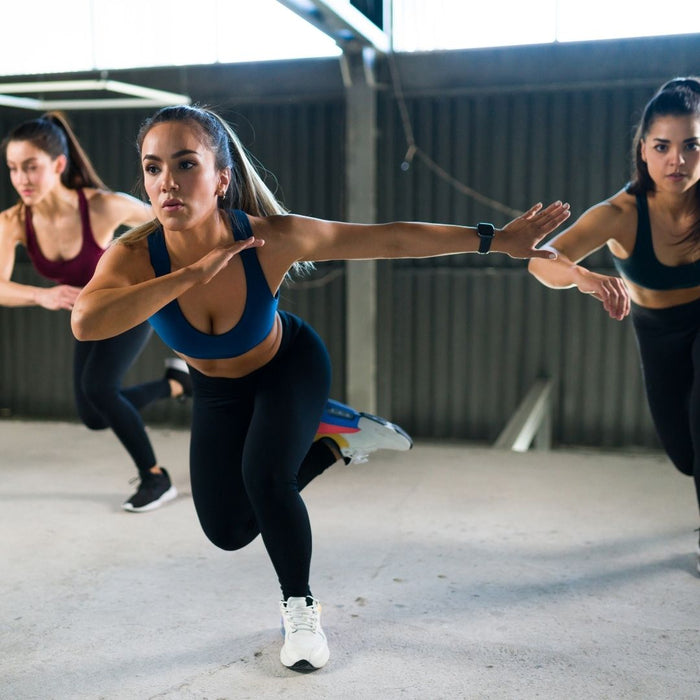 Three woman in a gym doing HIIT training