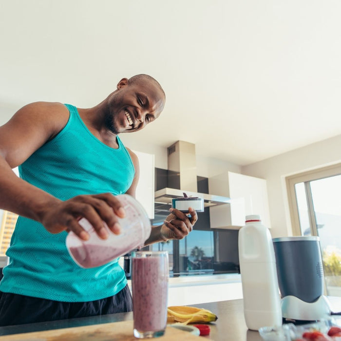 a black guy making himself a smoothie in the kitchen