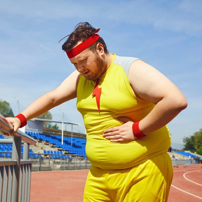 A bloated guy holding his stomach