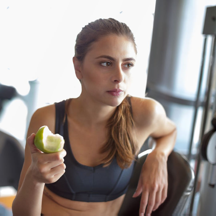 a woman at the gym eating an apple