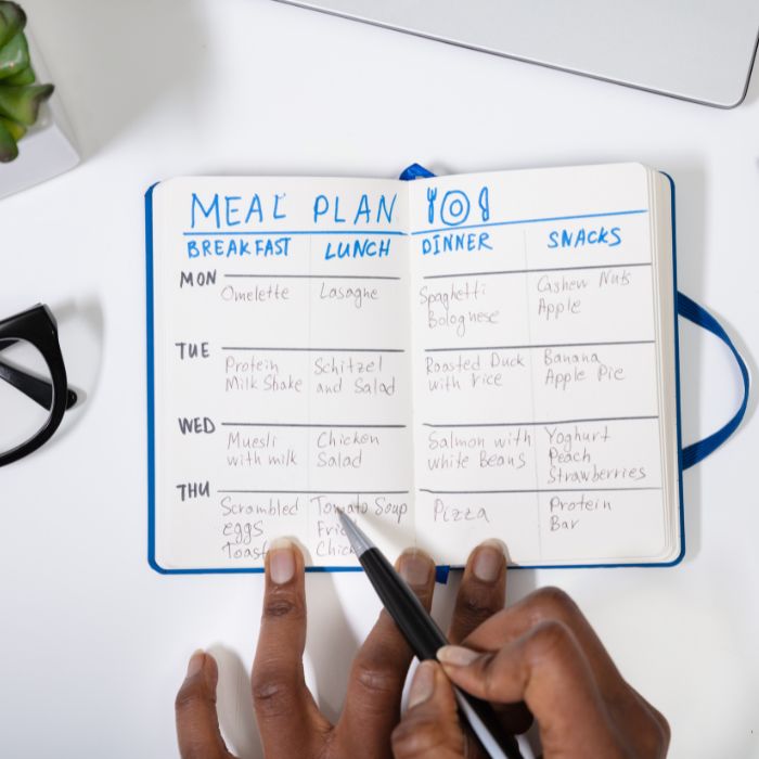 person writing out a meal plan